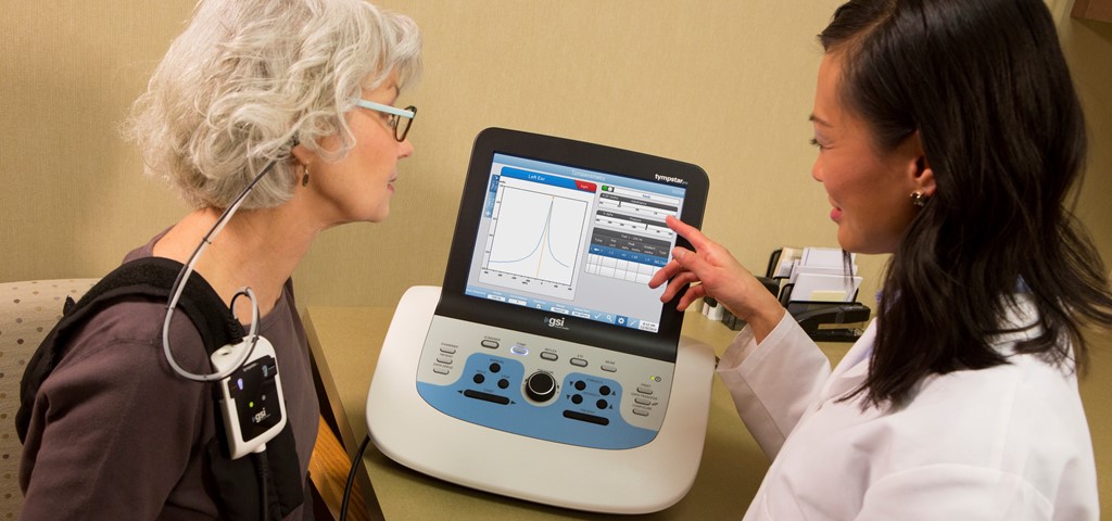 An audiologist explaining tympanometry test results to a patient