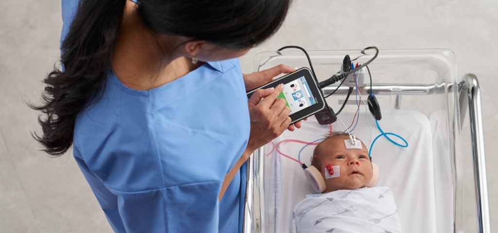 A nurse screening an infant with AABR testing